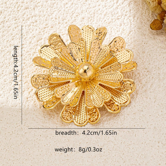 Gold floral brooch with measurements on a beige background