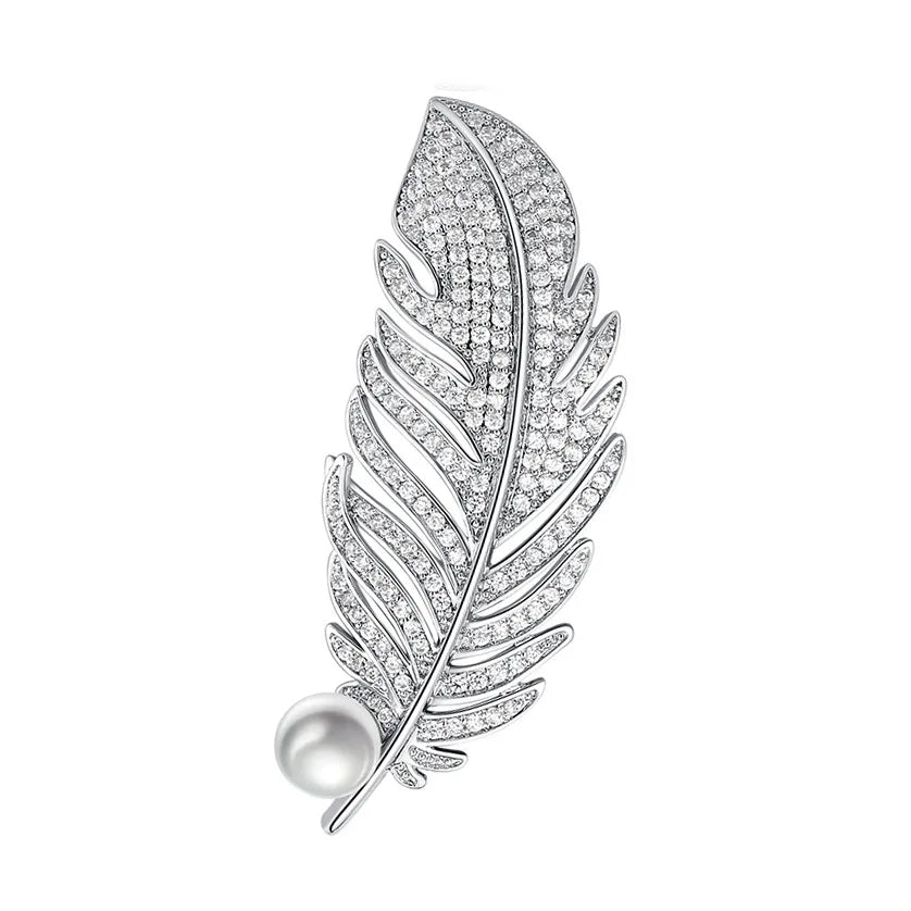 Silver feather-shaped brooch with embedded diamonds on a white background