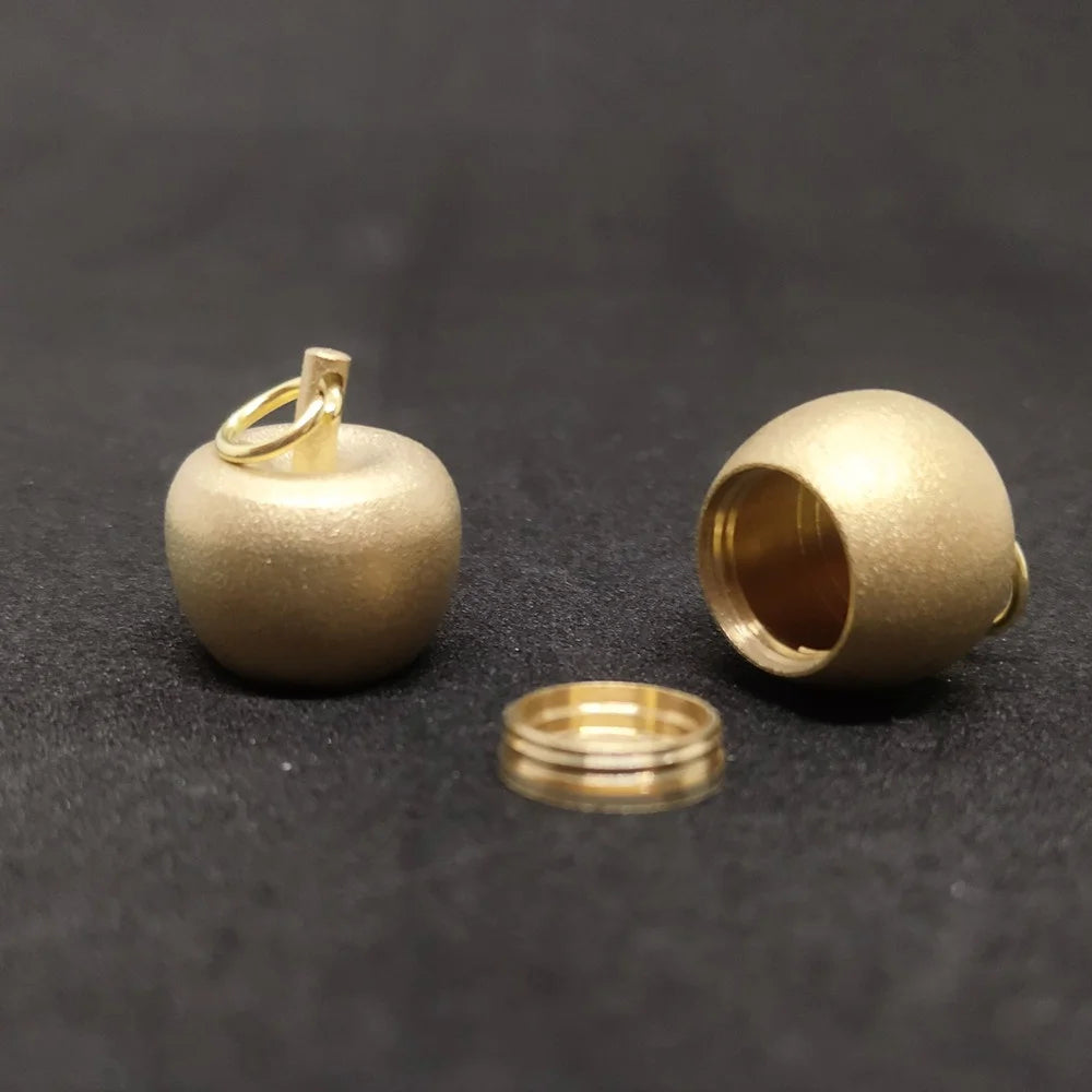 Open brass apple storage locket showing inner compartment and threaded screw cap design