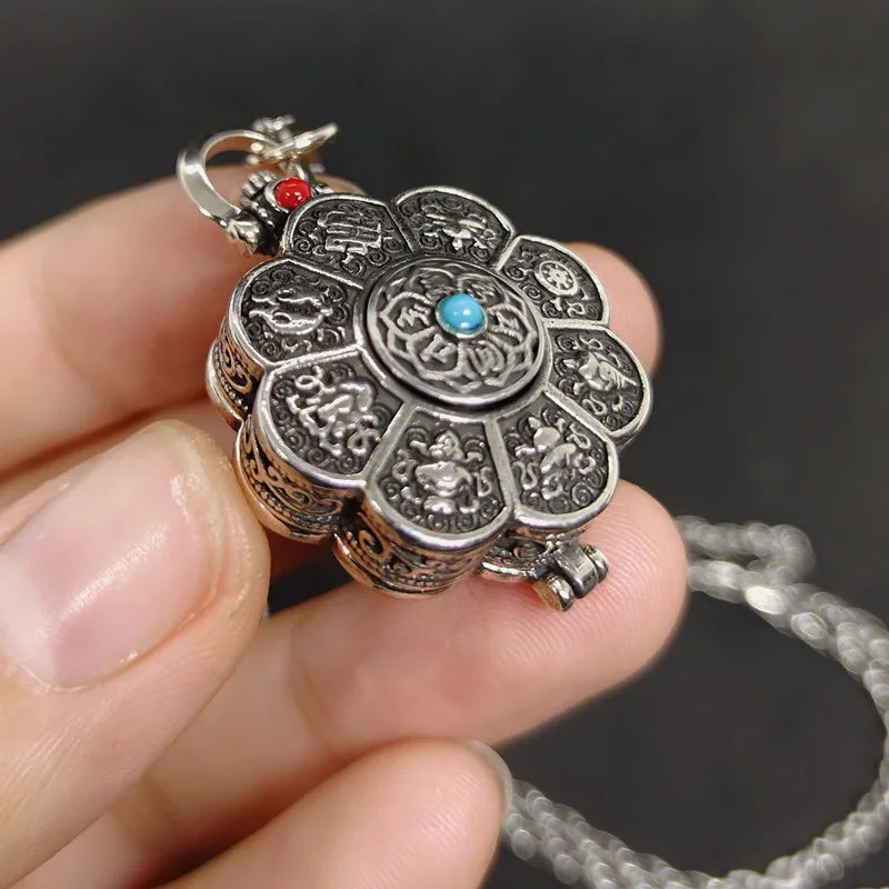 Hand holding vintage lotus opening locket pendant with engraved decorative details