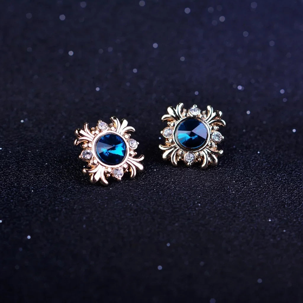 Gold brooch with blue gemstones on a dark background