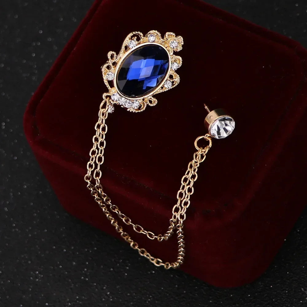 Gold brooch with blue gemstone on a dark background