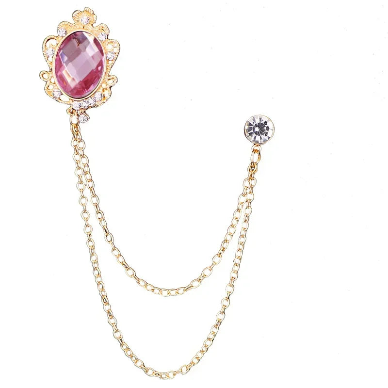 Gold brooch with a pink gemstone on a white background