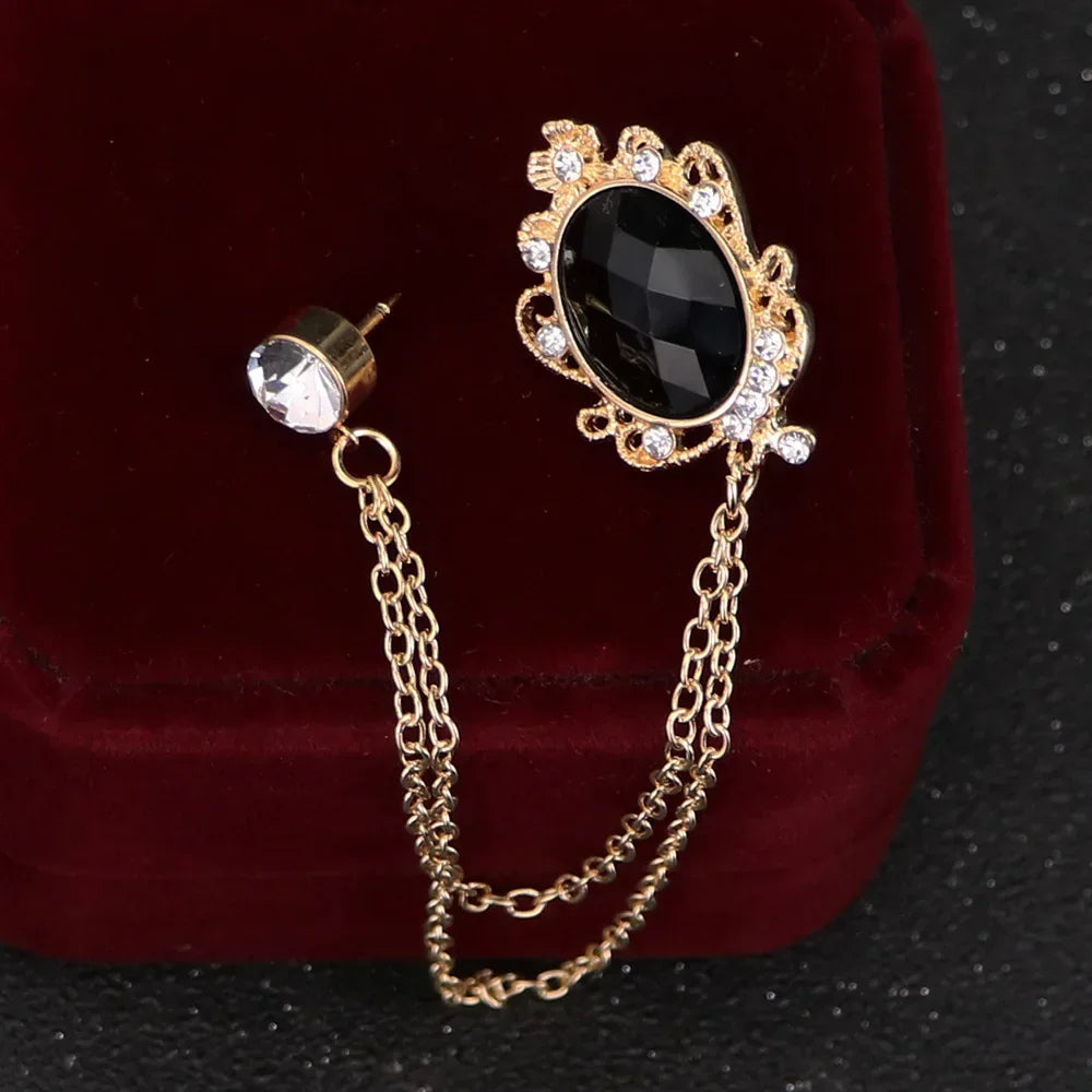 Gold brooch with black gemstone on a red velvet background