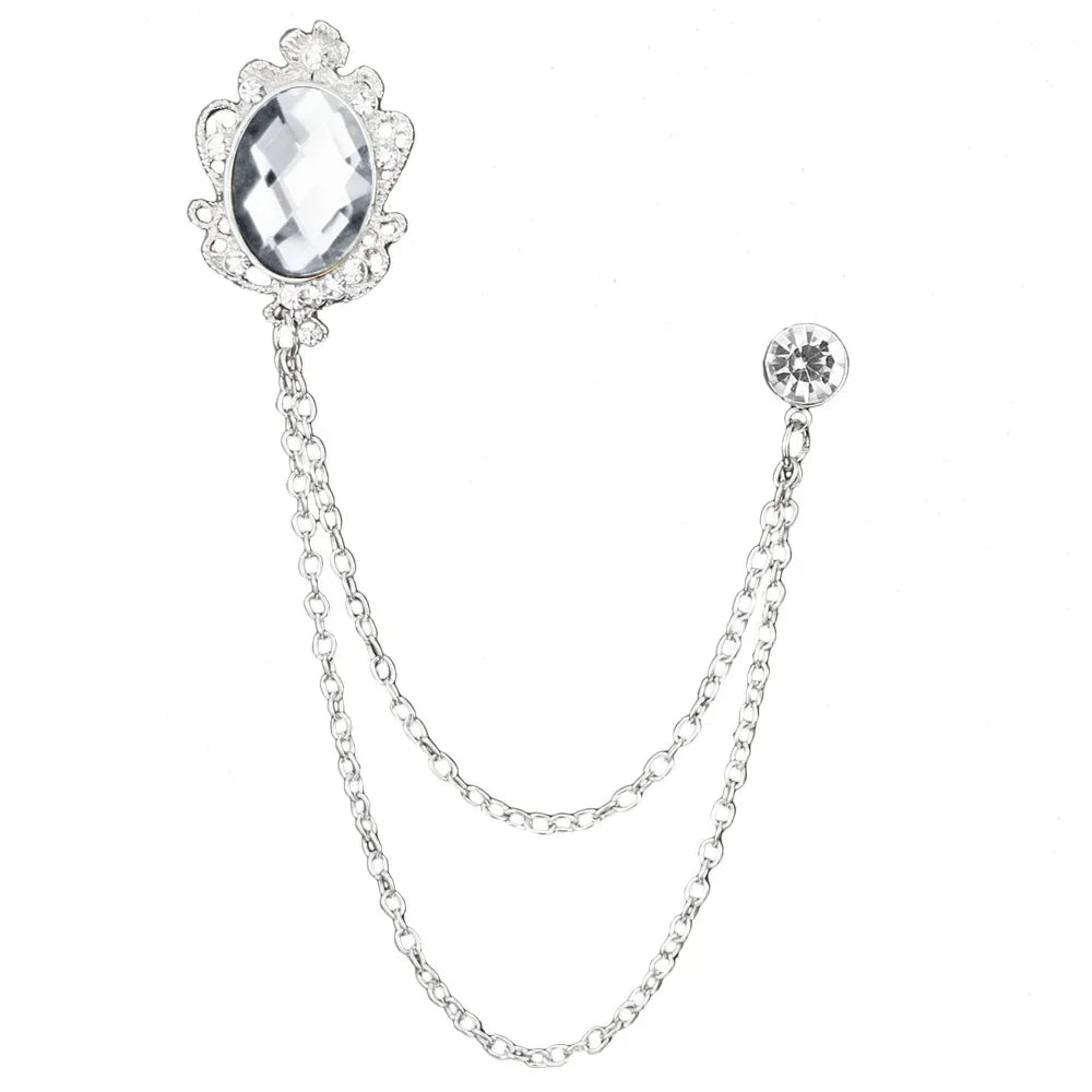 Silver brooch with a large central gemstone and smaller gemstones on a chain, on a white background.