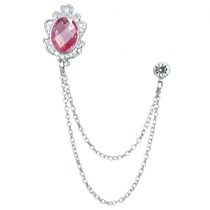 Silver brooch with a pink gemstone on a white background