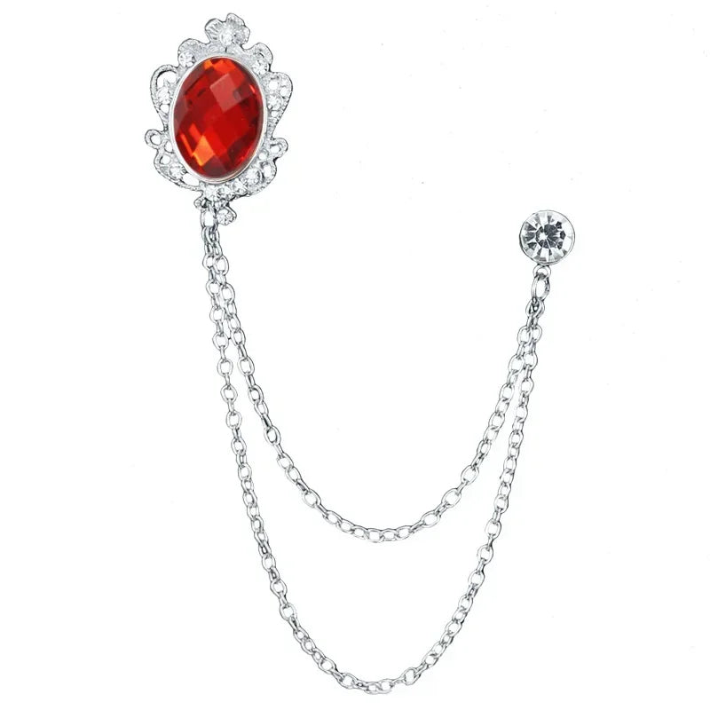 Silver brooch with a red gemstone on a white background