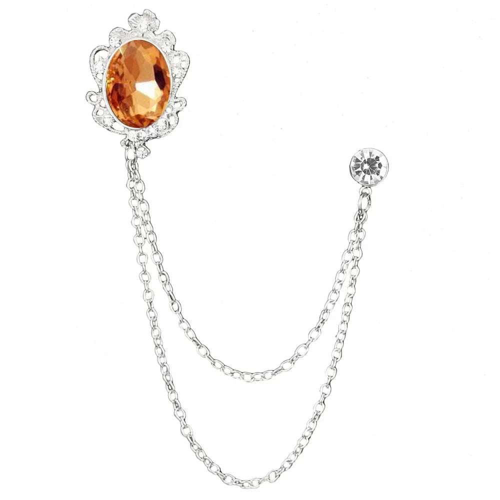 Silver brooch with an orange gemstone on a white background