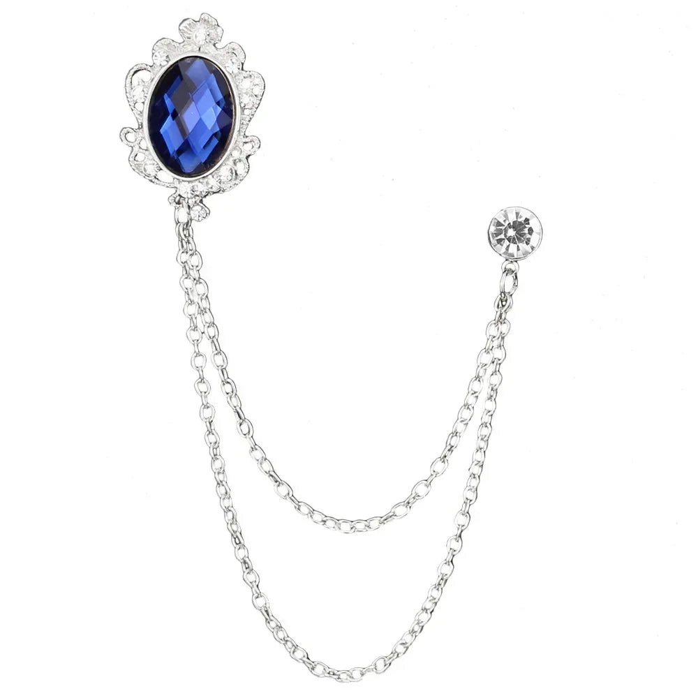 Silver brooch with a blue gemstone on a white background