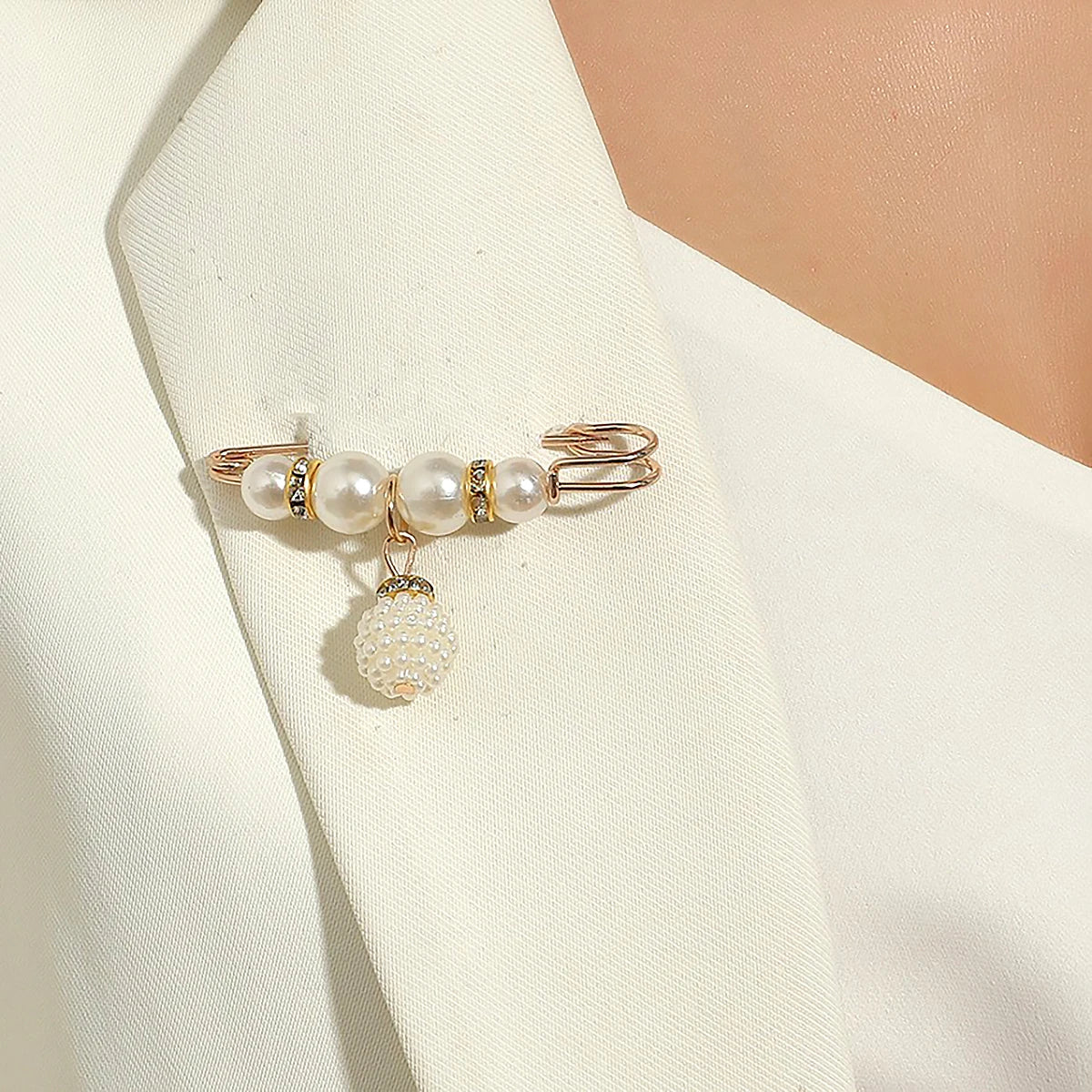 Gold pearl fashion accessory on white fabric background