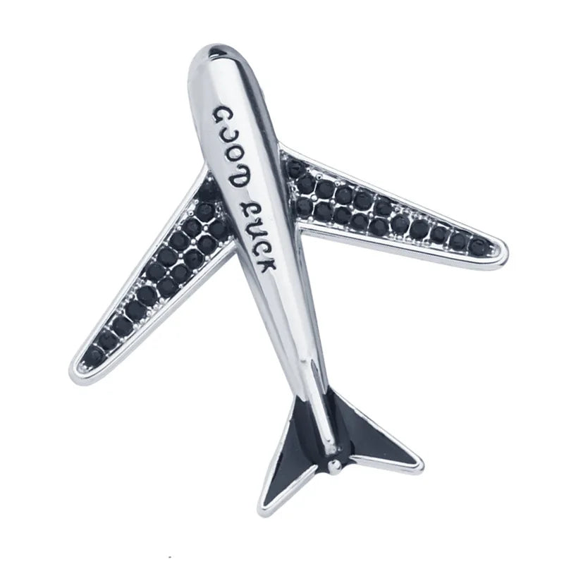 Airplane lapel pin with Good Luck engraving on white background.