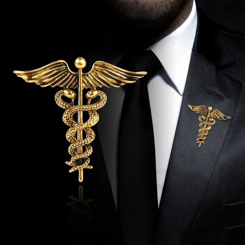 Gold caduceus brooch on a black suit with white shirt