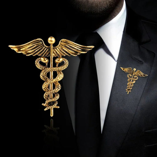 Gold caduceus brooch on a black suit with white shirt