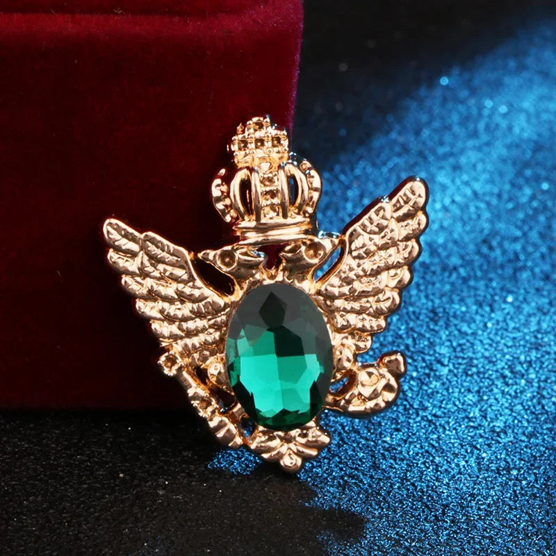 Gold angel pendant with green gemstone luxury fashion jewelry on blue and red fabric background