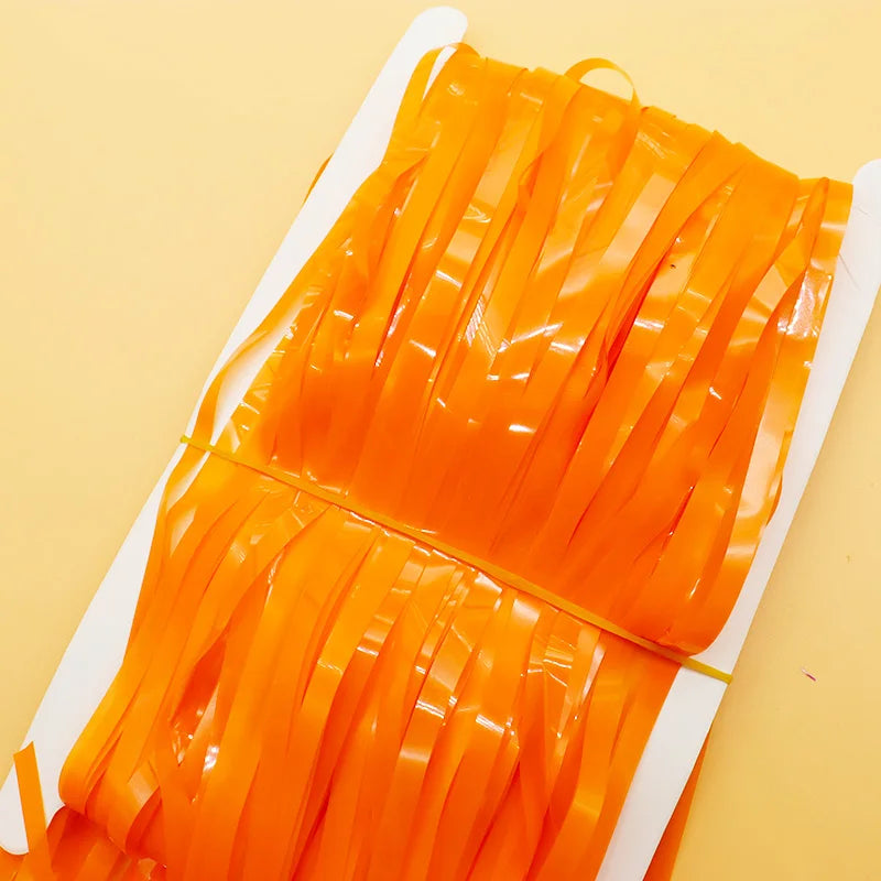 Orange ribbons on a white cardboard sheet against a yellow background