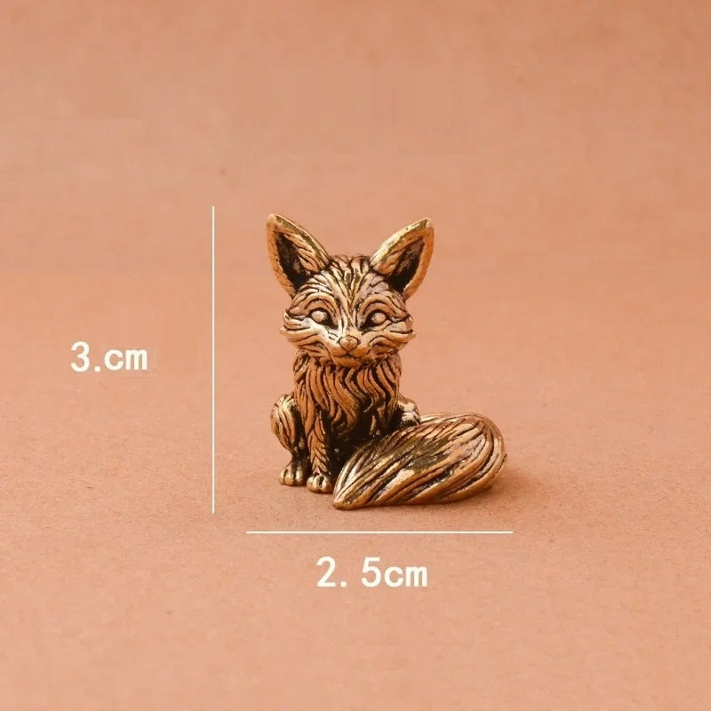 Bronze fox figurine with measurements on a brown background
