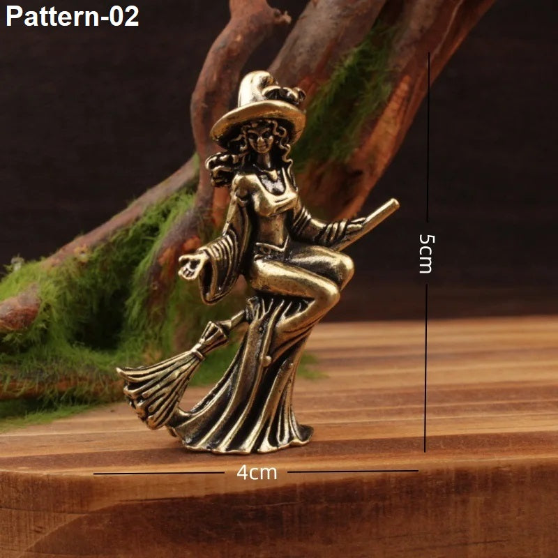 A small bronze-toned figurine of a seated witch on a broomstick, shown on a wooden surface with mossy branches in the background. White text in the top left reads 'Pattern-02', and black measurement lines with '4cm' and '5cm' indicate the figurine's dimensions.