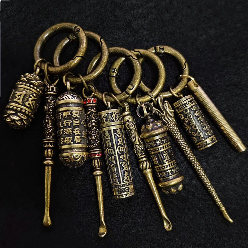 Collection of vintage brass DIY keychains on black background