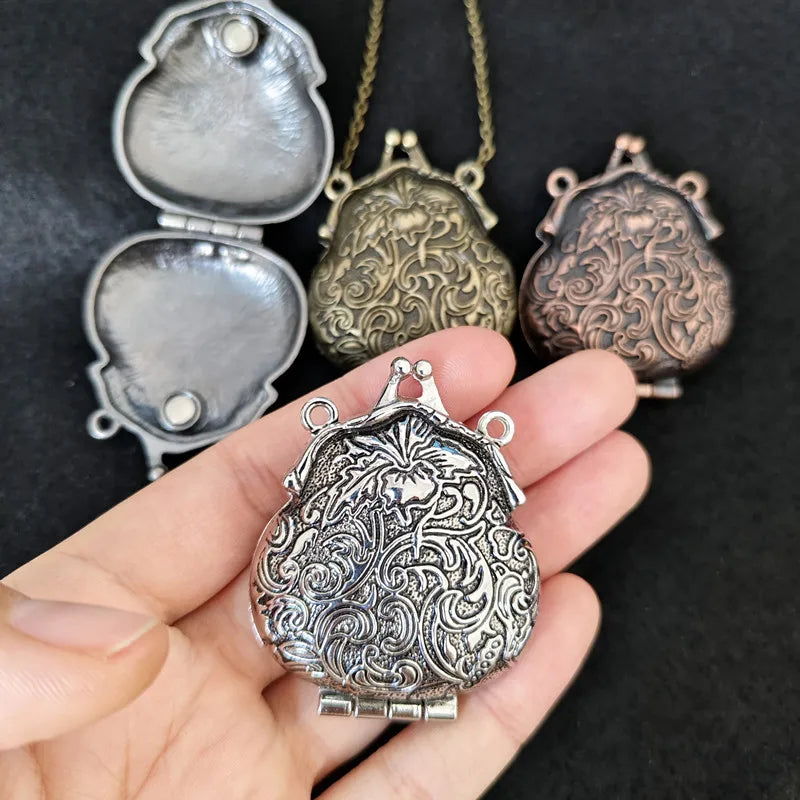 Decorative silver locket held in a hand with other similar lockets in the background.