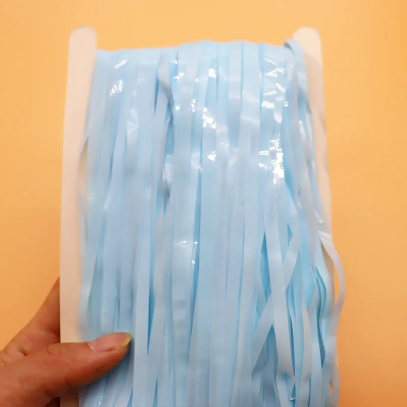 Roll of light blue ribbons held against an orange background