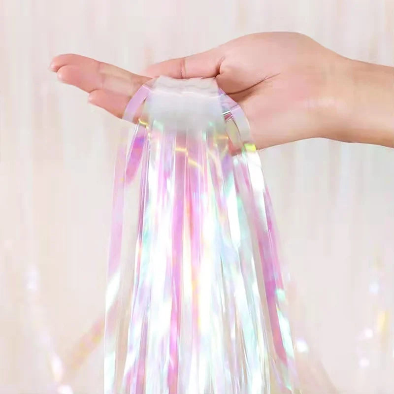 Hand holding a bundle of colorful tinsel against a light background