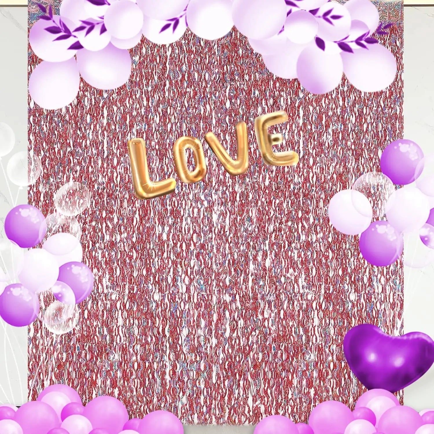 Decorative setup with 'LOVE' balloons, purple and white balloons, and floral elements on a textured backdrop.