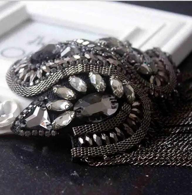 Decorative rhinestone shoulder accessory on black textured surface