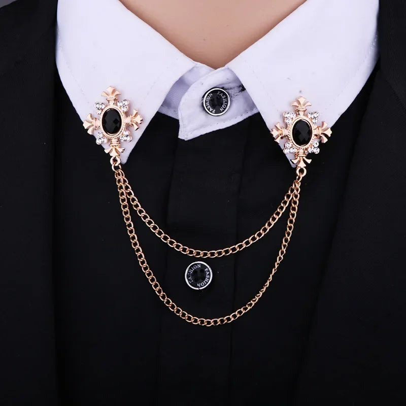 Crystal cross chain brooch pins styled on a white shirt collar with gold and black decorative chains