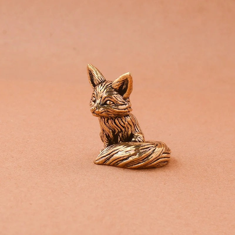 Bronze fox figurine on a peach-colored background