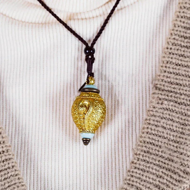 Vintage conch shell pendant necklace worn with casual outfit featuring elegant ocean-inspired styling