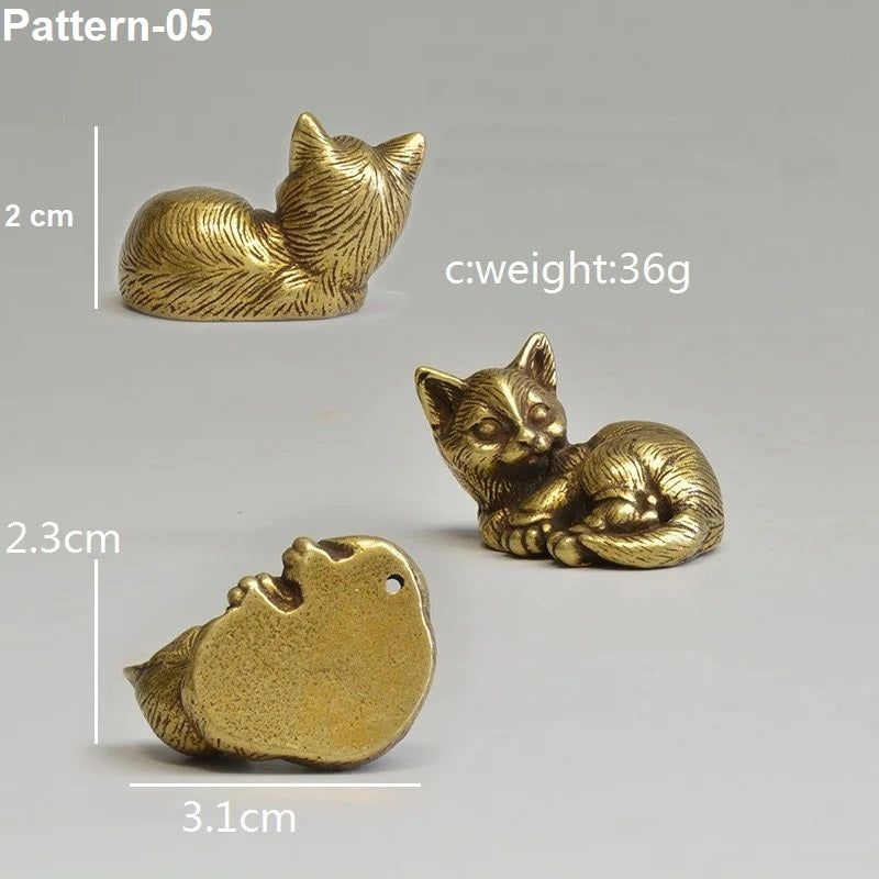 Three gold cat figurines with measurements and weight details on a gray background
