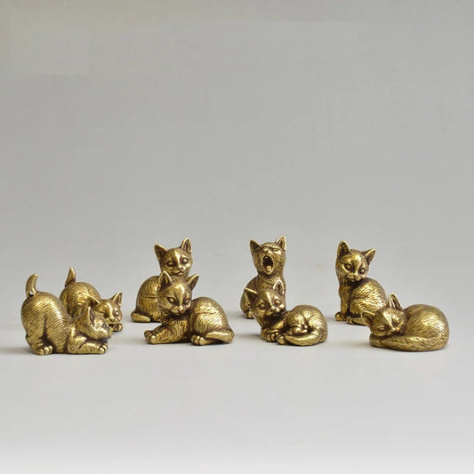 Set of six small gold cat figurines on a light gray background