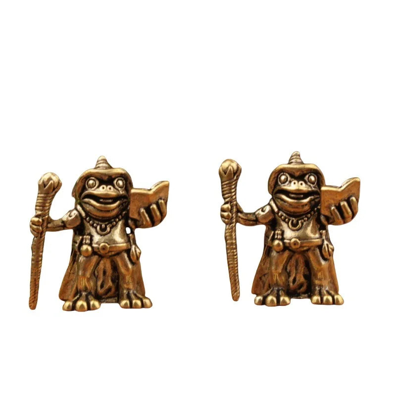 Pair of gold frogman figurines holding a staff and shield on a white background
