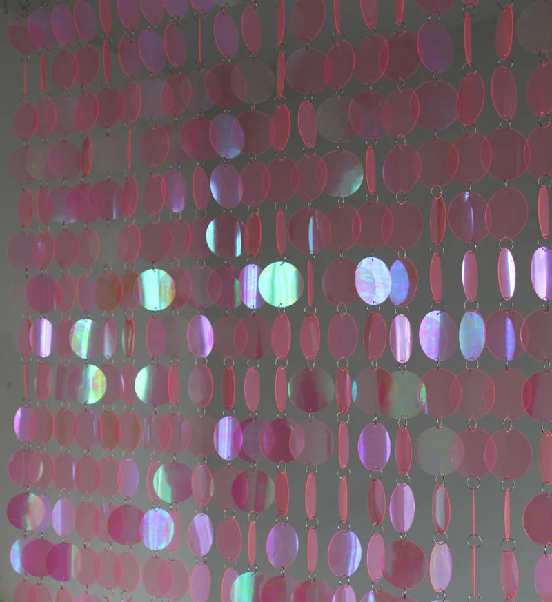 Close-up of a pink sequin curtain with a dark background