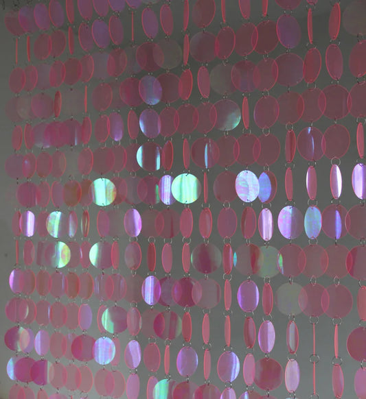 Close-up of a pink sequin curtain with a dark background