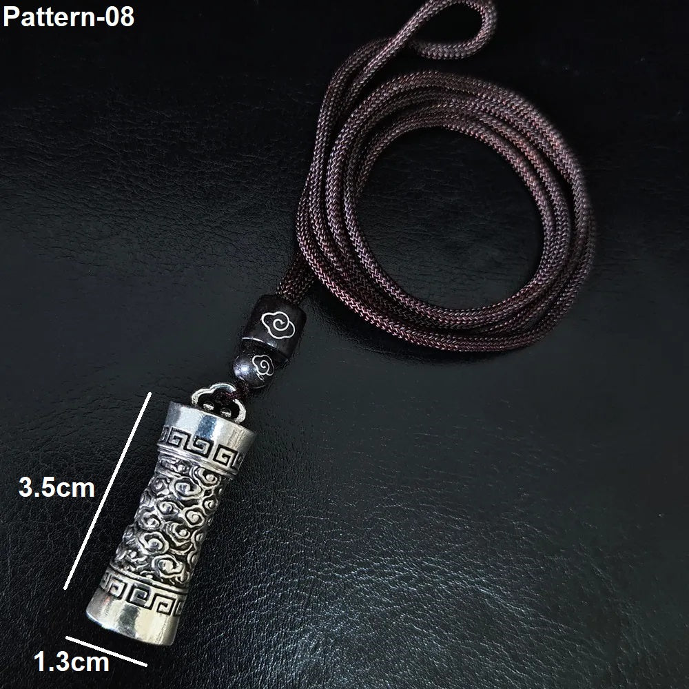Silver pendant on a dark textured background with measurements indicated