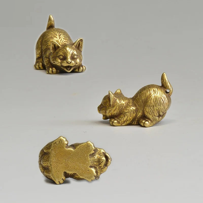 Three gold cat figurines on a gray background