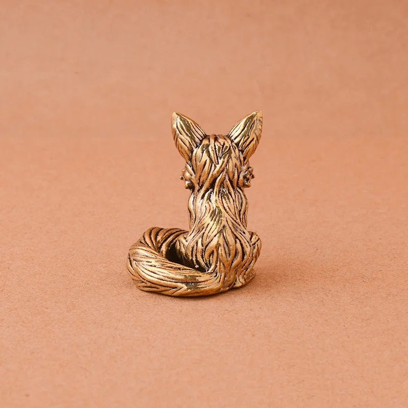 Bronze fox figurine on a pink background