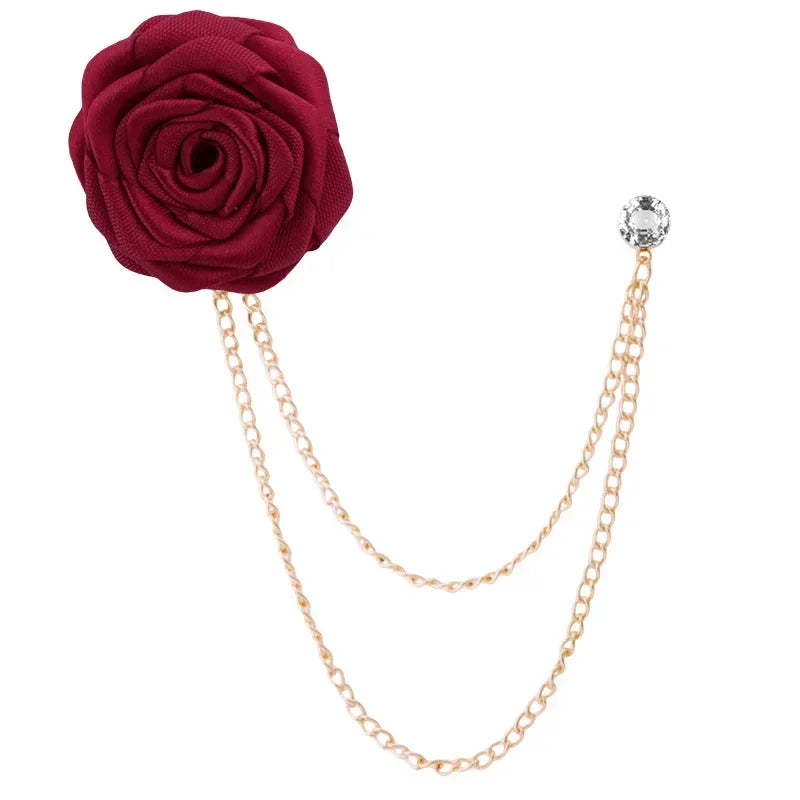 Red rose-shaped brooch with gold chain on a white background