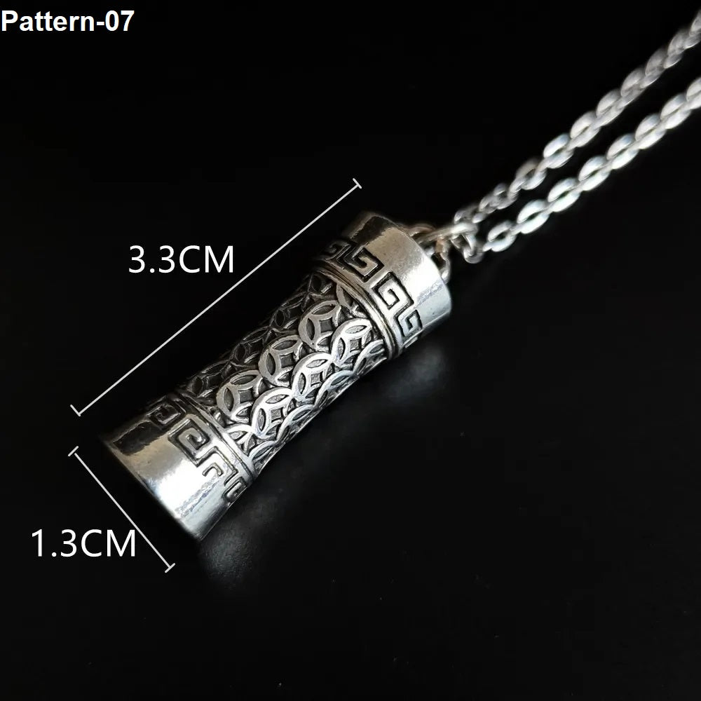 Silver pendant with intricate design on a black background