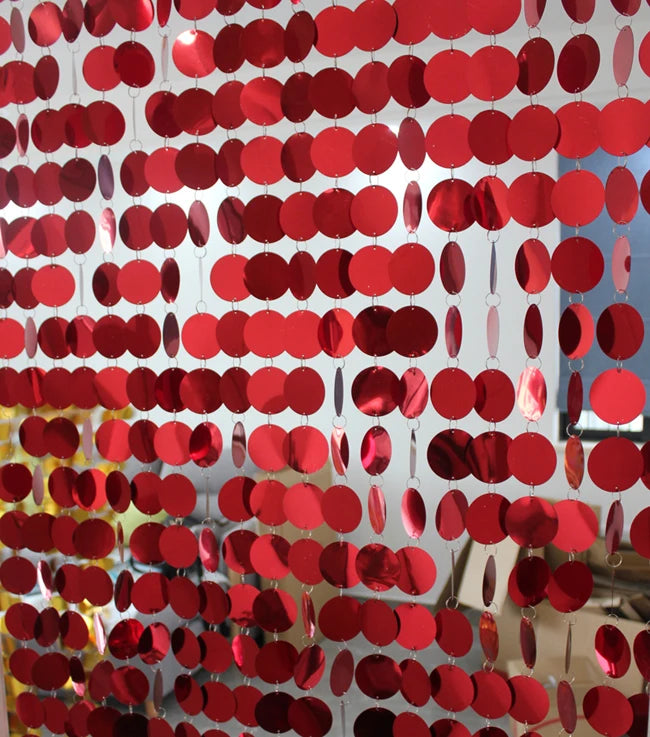 Red circular disc sequin curtain with a blurred indoor background
