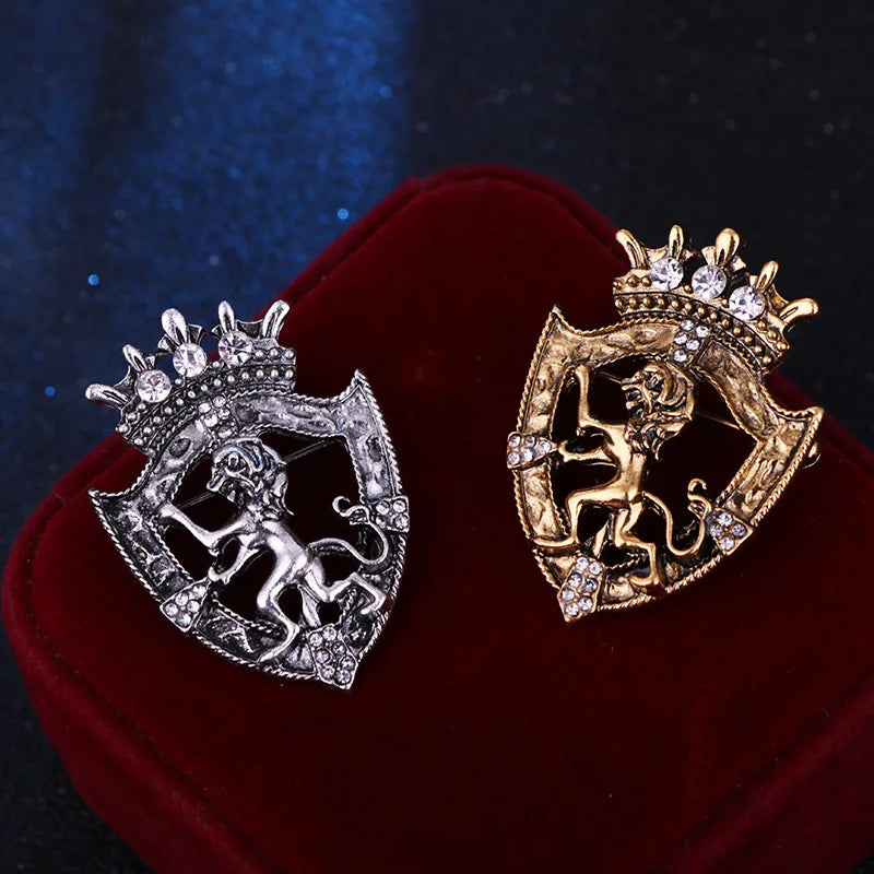 Silver and gold lion brooch collection on elegant fabric background