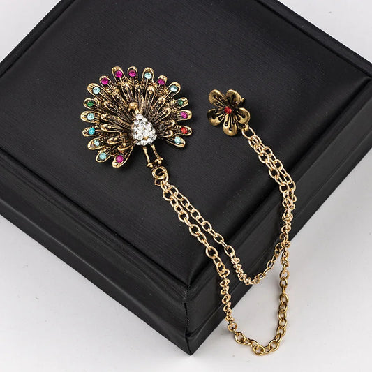 Gold gemstone brooch with chain luxury fashion jewelry displayed on black box