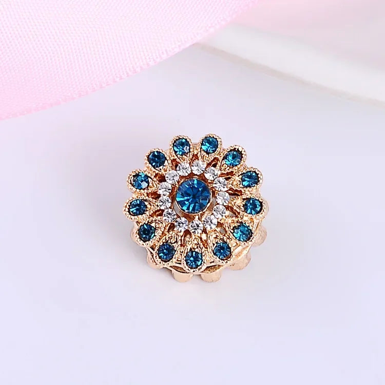 Blue flower crystal hijab brooch pin with magnetic no-hole closure on a light pink background