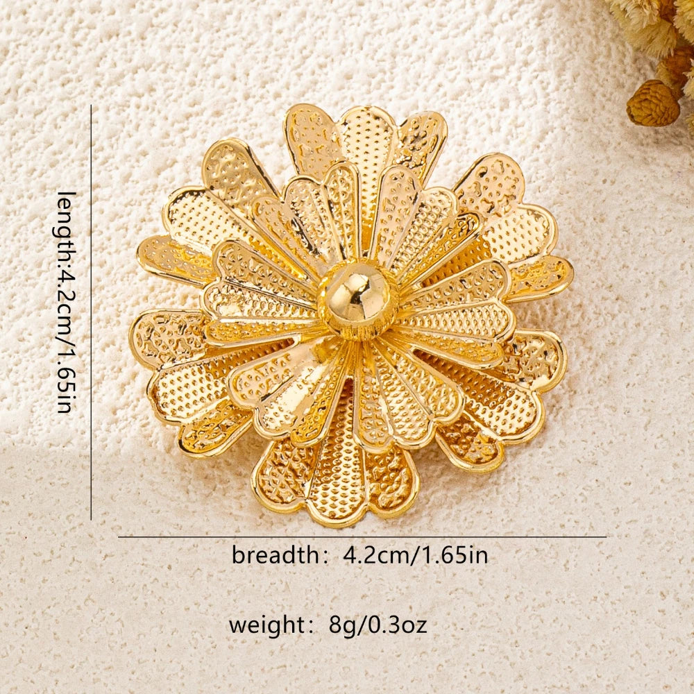 Gold floral brooch with measurements on a beige background