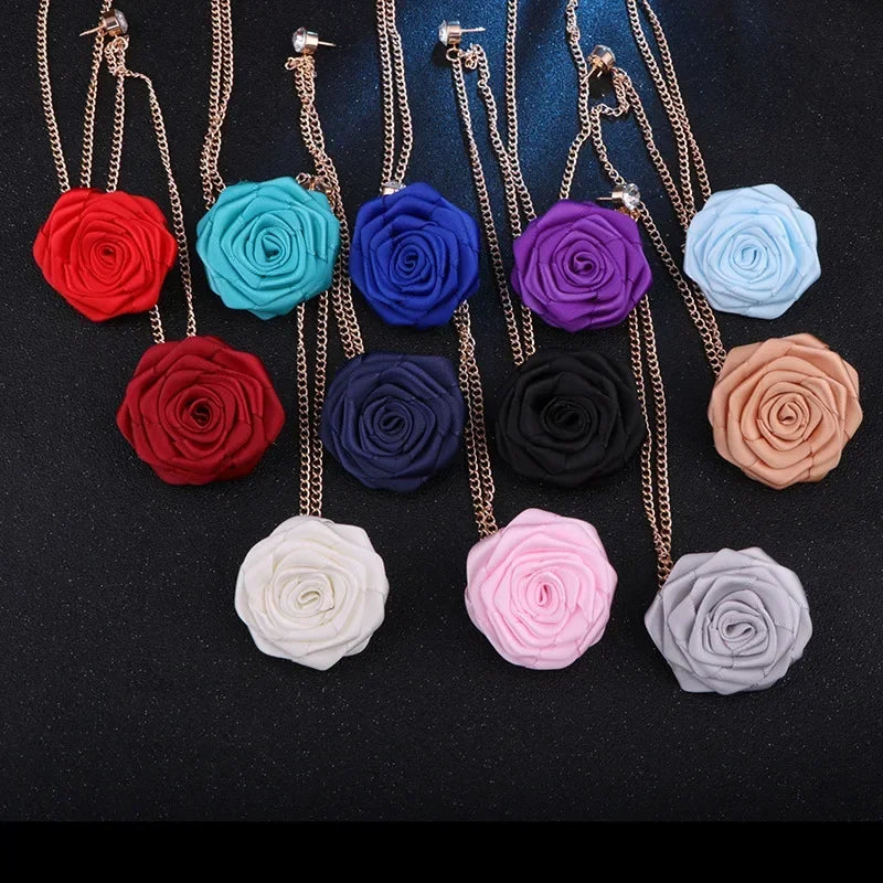 Collection of handmade fabric flower brooch pins in multiple color variations on black background.
