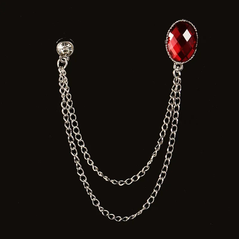 Silver chain brooch with red crystal gemstone on black background