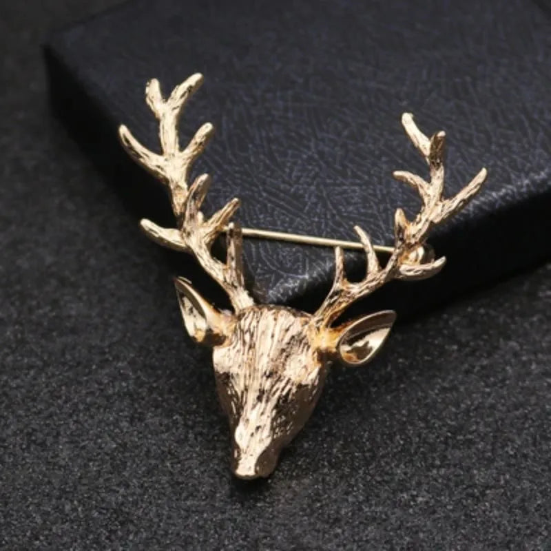 Gold deer head brooch on a dark textured background