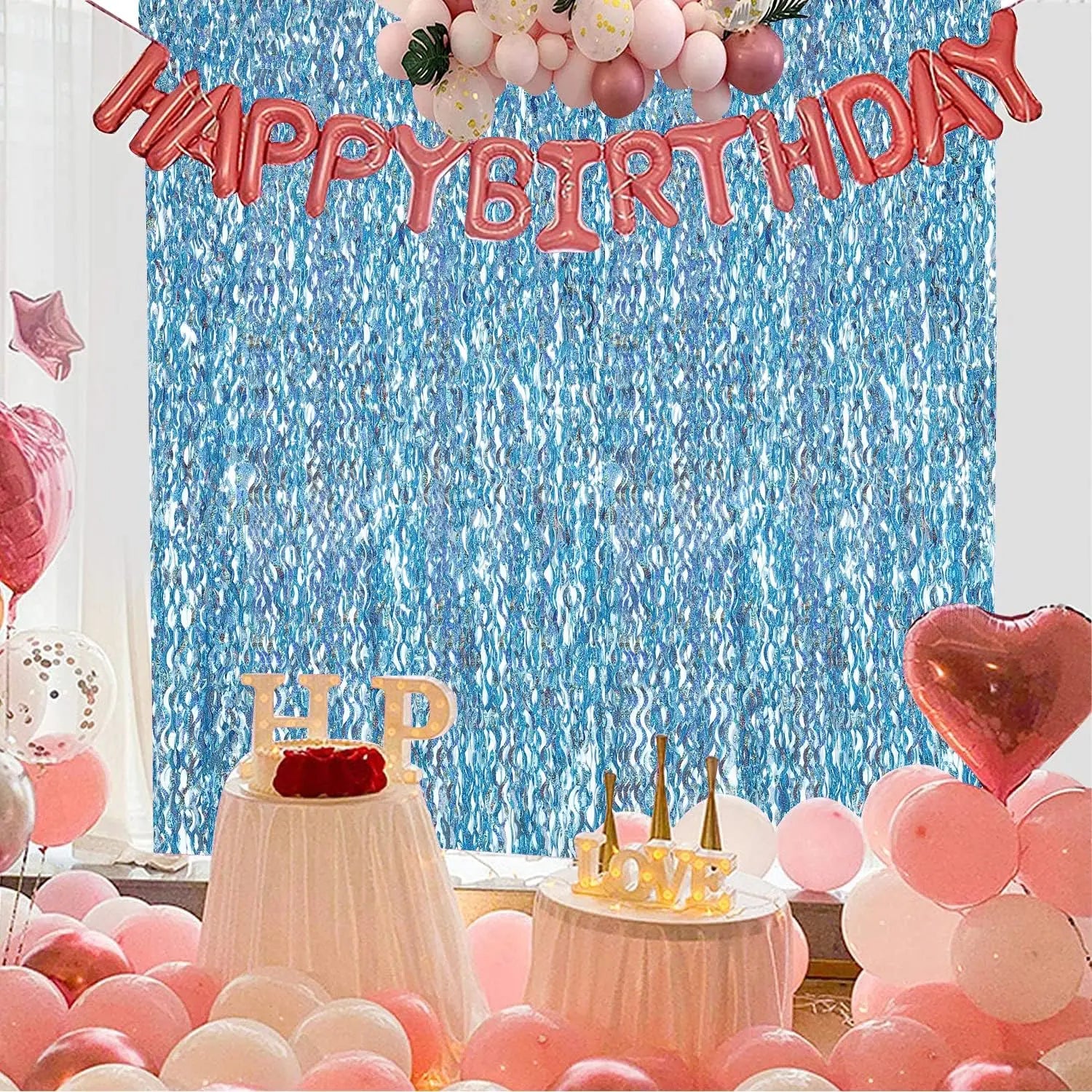 Birthday party decoration setup with metallic fringe backdrop balloons cake table and photo booth background