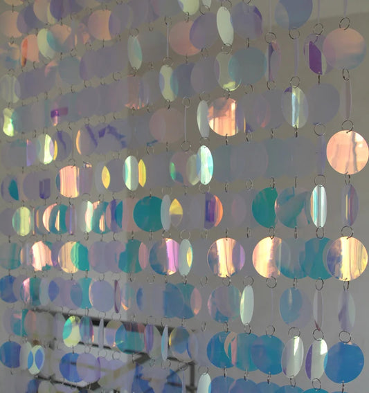 Iridescent circular beads sequin hanging against a neutral background